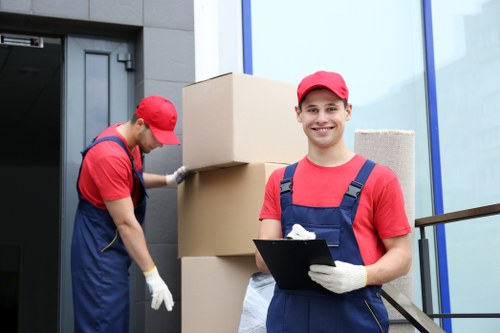 Removalists carrying furniture down stairs in Streatham